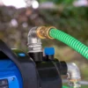 cuve-ibc-blanc-avec-pompe-220V-1000L-nettoye-palette-acier-plastique-close-up-pompe-avec-tuyau-sortant.webp