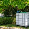 cuve-ibc-blanc-avec-pompe-220V-1000L-nettoye-palette-acier-plastique-vue-de-droite-dans-environnement-de-jardin.webp