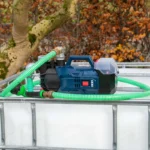 cuve-ibc-blanc-pompe-sur-batterie-1000L-nettoye-palette-acier-plastique-vue-de-devant-avec-tuyau.webp