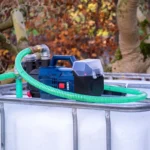 cuve-ibc-blanc-pompe-sur-batterie-1000L-nettoye-palette-acier-plastique-vue-de-droite-devant-avec-tuyau.webp