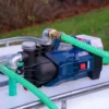 cuve-ibc-blanc-pompe-sur-batterie-1000L-nettoye-palette-acier-plastique-vue-de-gauche-devant-avec-tuyau.webp