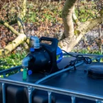cuve-ibc-noir-avec-pompe-220V-1000L-renouvele-palette-acier-plastique-zijaanzicht-achteraanzicht-zonder-uitgaande-slang.webp