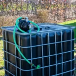 cuve-ibc-noir-avec-pompe-220V-1000L-renouvele-palette-acier-plastique-zijaanzicht-vooraanzicht-met-uitgaande-slang.webp