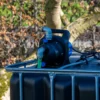 cuve-ibc-noir-avec-pompe-220V-1000L-renouvele-palette-acier-plastique-zijaanzicht-zonder-uitgaande-slang.webp