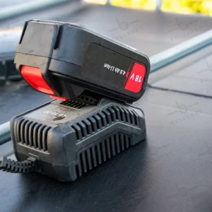 cuve-ibc-noir-avec-pompe-sur-batterie-1000L-renouvele-palette-acier-plastique-close-up-batterij-sur-chargeur.webp